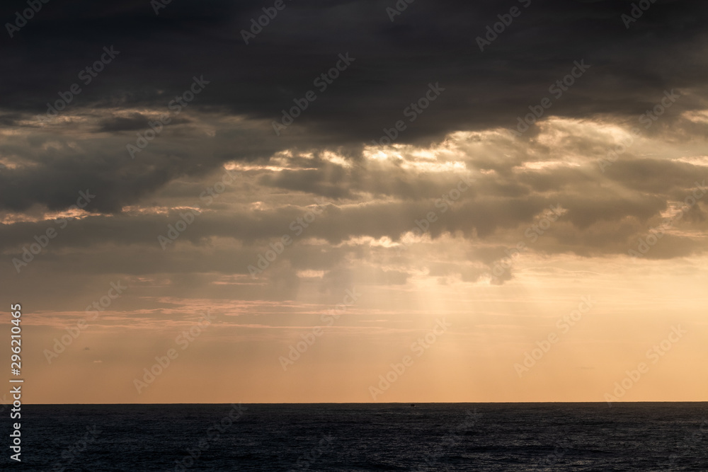 Sunrays through storm clouds during sunrise Sunrays through storm clouds during sunrise