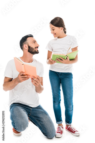 happy father holding book and looking at daughter isolated on white © LIGHTFIELD STUDIOS