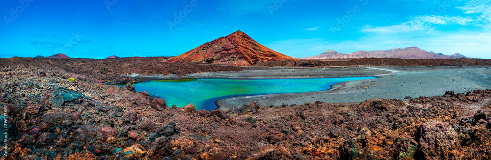 Impressive and scenic volcanic nature unique in Timanfaya National Park.Red mountain and green puddle near the sea coast in Canary island,Lanzarote.Spain beachs