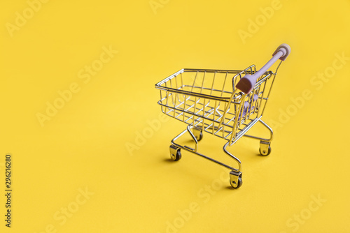 Supermarket trolley on the yellow background