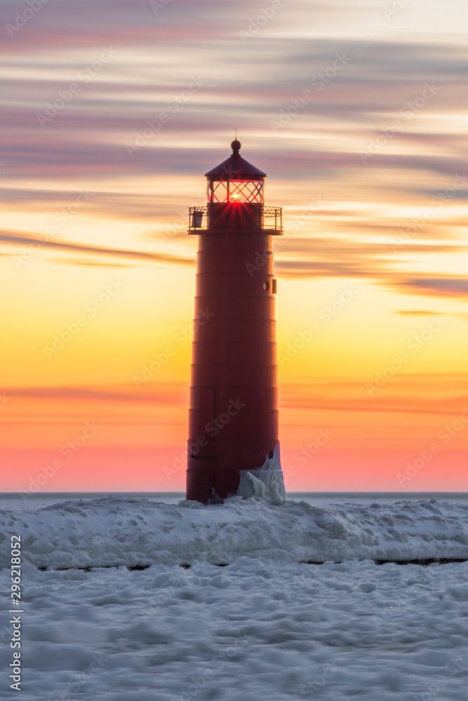 lighthouse with ice at sunset