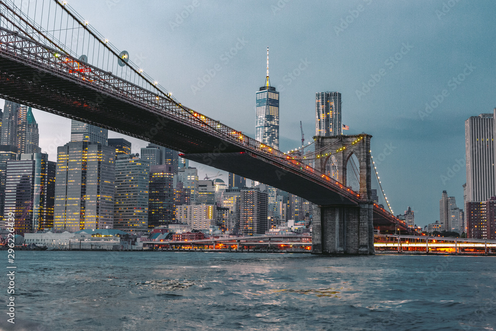 Fototapeta premium Brooklyn Bridge and Manhattan Skyline on a Moody Night After Sunset on the East River from Brooklyn Waterfront in Dumbo