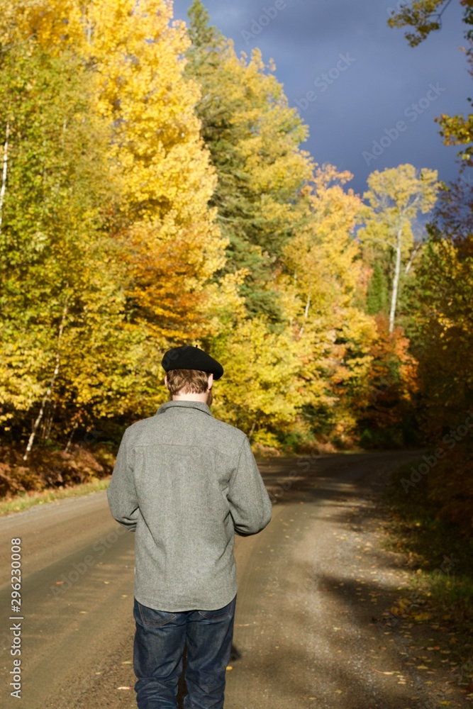 Man walking away down a colourful autumn lane Man walking away down a colourful autumn lane