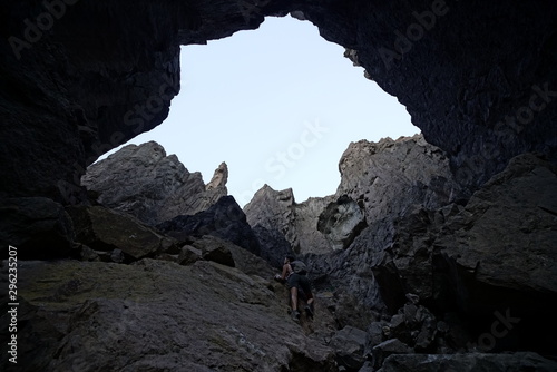 mujer joven escala una pared de rocas en un paisaje desértico