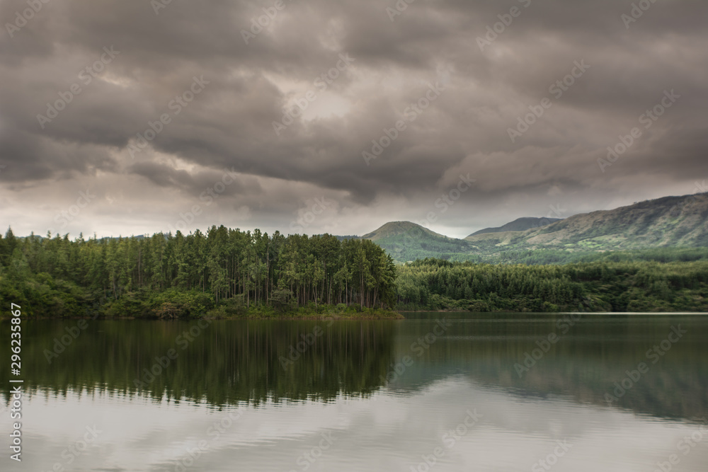 atardecer lluvioso en el lago, rodeado de pinos y cerros atardecer lluvioso en el lago, rodeado de pinos y cerros