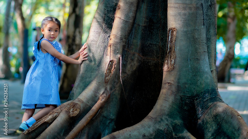 Portrait of Asia girl playing on big tree