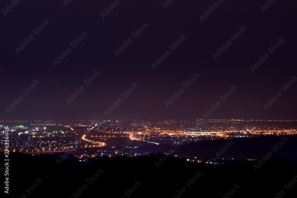 Aerial night view of a countryside. Beautiful landscape panorama at night. Aerial view city on the mountain.