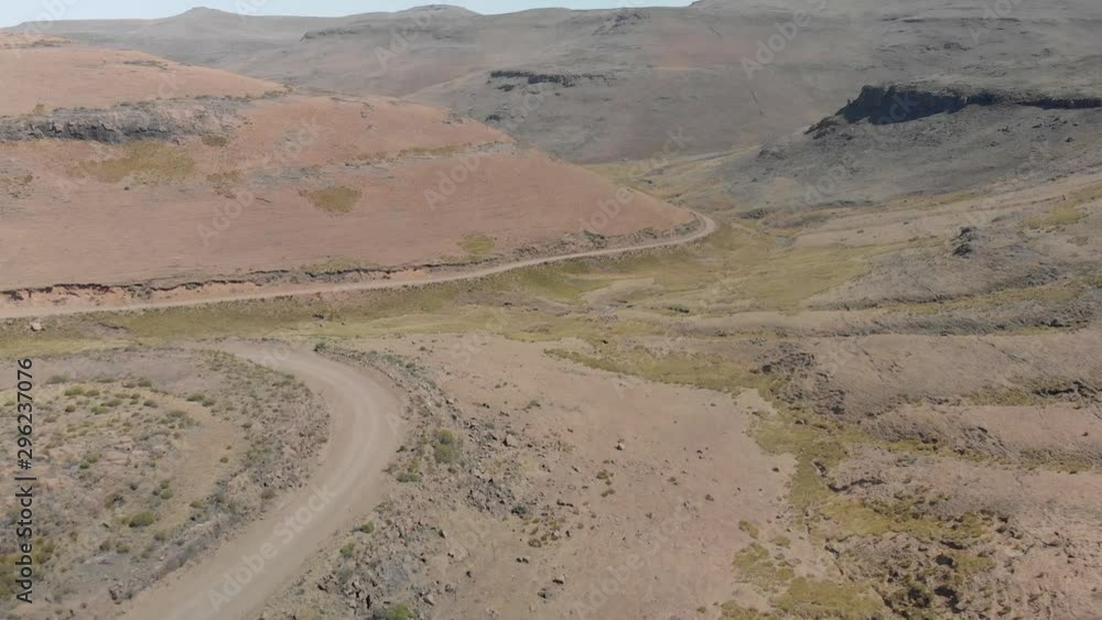 aerial shot following two mountain bikers climbing up a gravel road mountain pass aerial shot following two mountain bikers climbing up a gravel road mountain pass