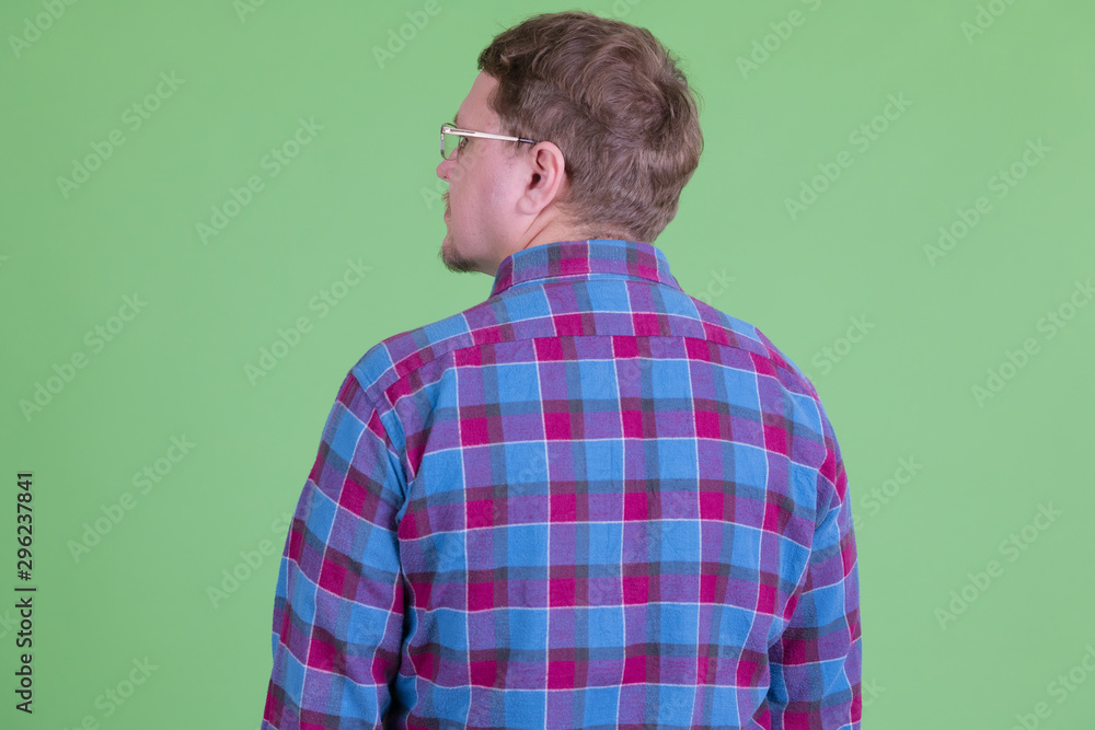 Rear view of overweight bearded hipster man with eyeglasses Rear view of overweight bearded hipster man with eyeglasses