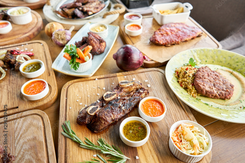 Beef meat cut according to the Argentine style, called asado. Barbecue restaurant menu. Many different food on the table. Dinner party or Banquet Beef meat cut according to the Argentine style, called asado. Barbecue restaurant menu. Many different food on the table. Dinner party or Banquet