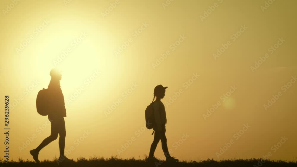 Parents and two children walking in the mountains at the sunset time. Silhouette happy beautiful family during the travelling. Concept of friendly family and travel. Parents and two children walking in the mountains at the sunset time. Silhouette happy beautiful family during the travelling. Concept of friendly family and travel.