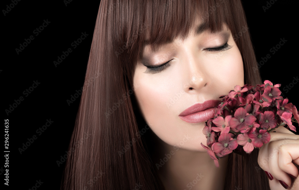 Beautiful model girl with healthy skin and long hair, closed eyes with flower to cheek. Beautiful model girl with healthy skin and long hair, closed eyes with flower to cheek.