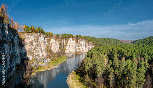 Panoramic footage of high steep rocky slopes of river Ay and mixed autumn forest with bright orange yellow colours; beautiful Ural landscape in fall season; popular touristic and rafting destination