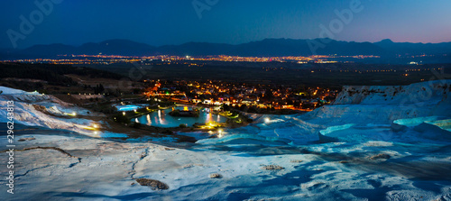 Fotografie Travertine terraces and the city of Pamukkale lit by lights at night