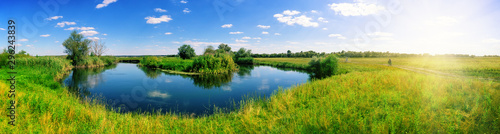 Turn of river in middle of meadow with green grass © alexlukin