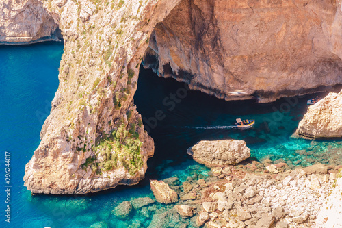 Fototapeta Naklejka Na Ścianę i Meble -  Blue Grotto in Malta. Pleasure boat with tourists runs. Natural arch window in rock