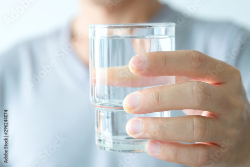 In the Morning, hand of man holding a clear glass of water for drinking.