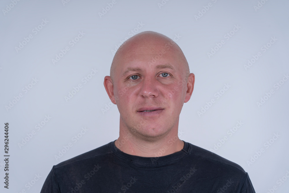 Portrait of middle-aged caucasian bald man looking straight at camera, close up Portrait of middle-aged caucasian bald man looking straight at camera, close up