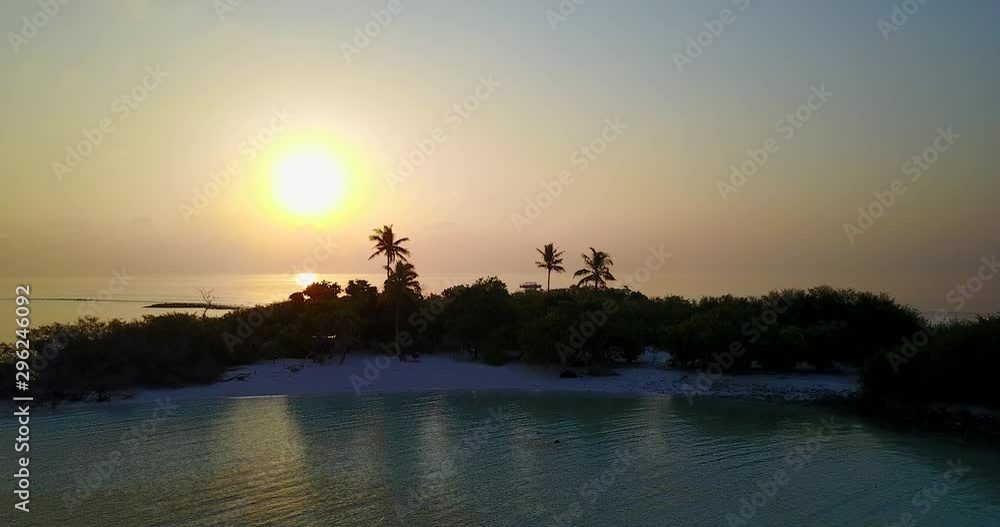Aerial slowly flying back away from the small tropical unmanned island in the Carribean on golden twilight sunset Aerial slowly flying back away from the small tropical unmanned island in the Carribean on golden twilight sunset