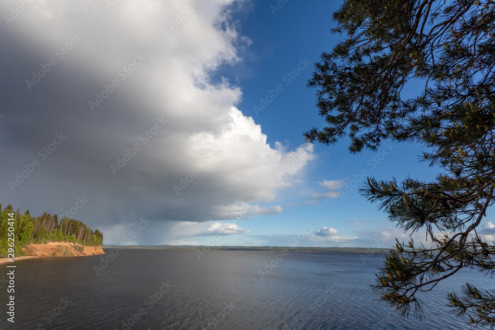 Summer landscape with a river, blue sky and cloud. Before a thunderstorm with rain