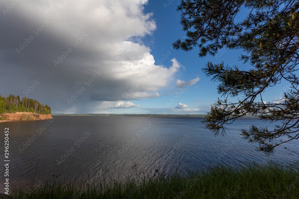 Summer landscape with a river, blue sky and cloud. Before a thunderstorm with rain