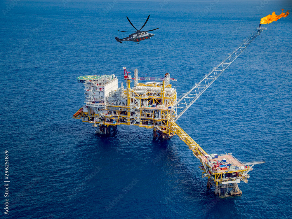 Offshore oil and gas rig platform with offshore helicopter transporting to oil rig at in the