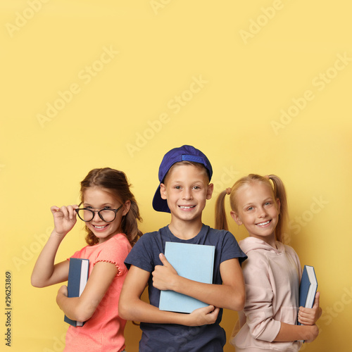 Little children with books on yellow background. Reading concept