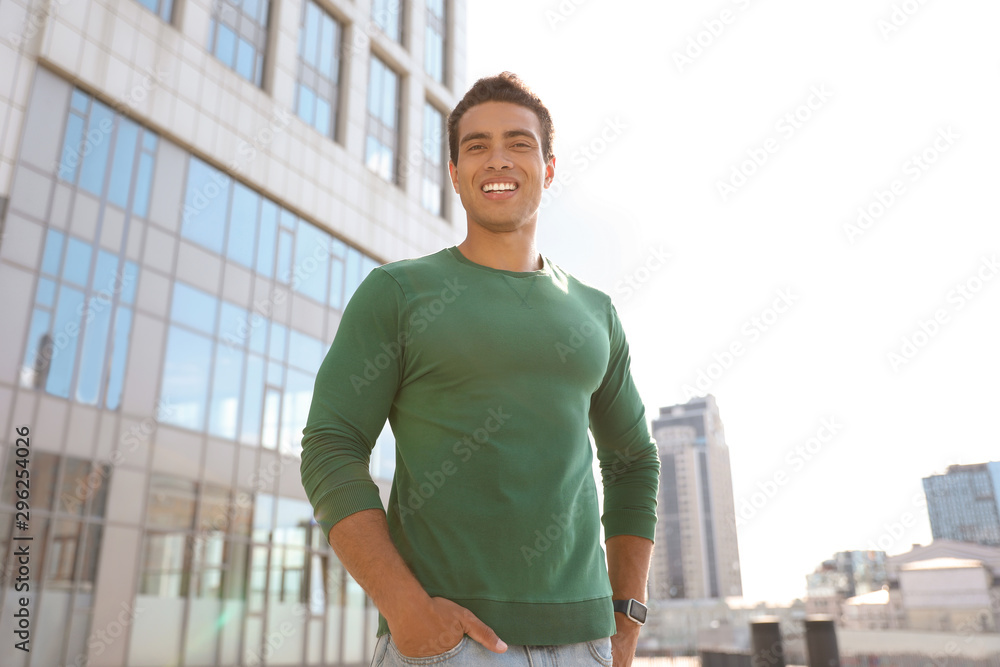 Portrait of handsome young African-American man on city street, low angle view Portrait of handsome young African-American man on city street, low angle view
