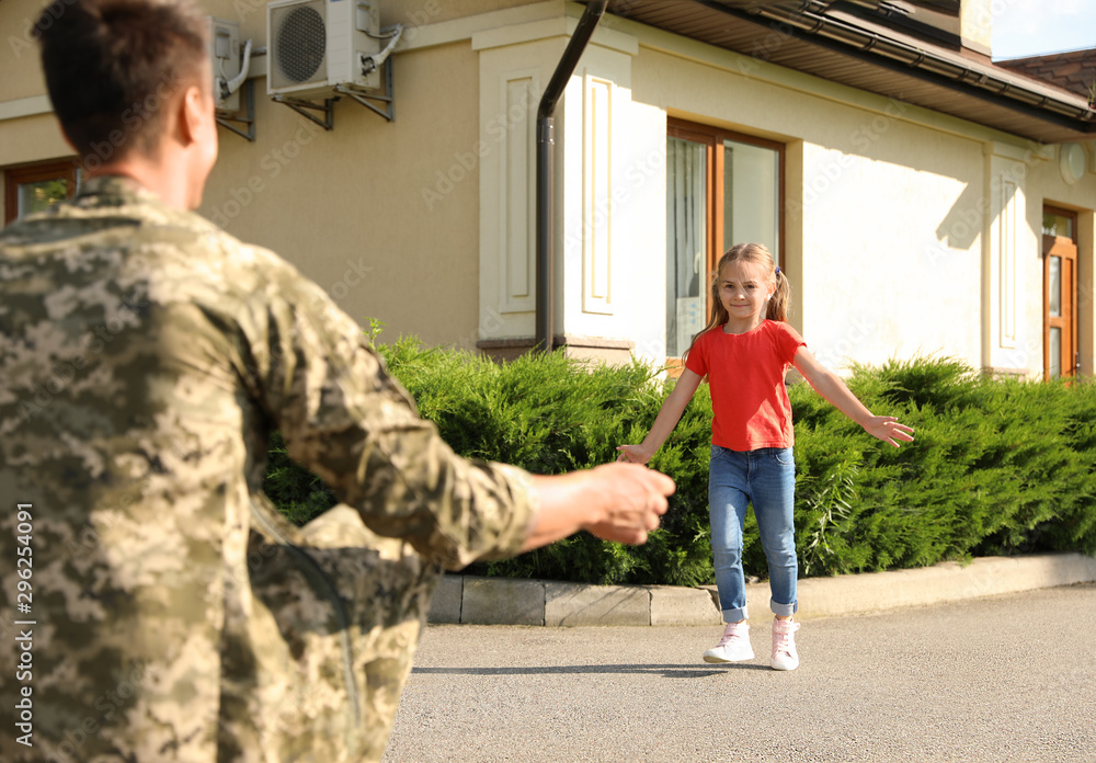 Fototapeta premium Father in military uniform and little daughter running to him outdoors