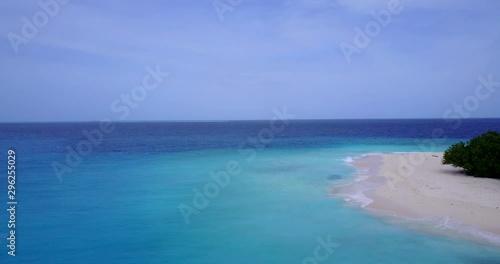 Aerial View of a desert island with White sand Beach Rangiroa Atoll, French Polynesia, sandbanks on high tide, drone ascending shot photo