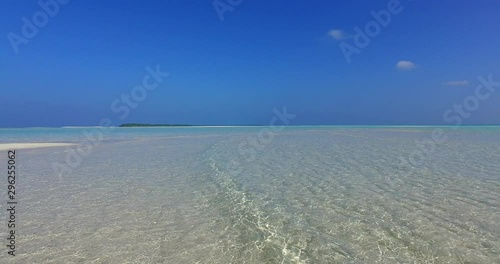 Tropical beach abstract background. White sandy beach on the Maldives, sandbank on high tide, waves splashing on the sand photo