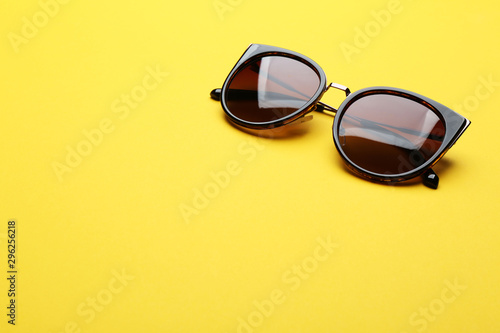 Stylish sunglasses on yellow background, space for text. Fashionable accessory