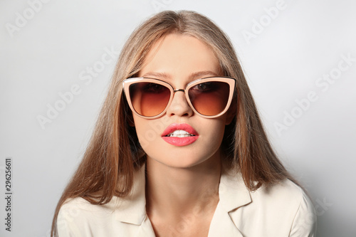 Wallpaper Mural Young woman wearing stylish sunglasses on light background Torontodigital.ca