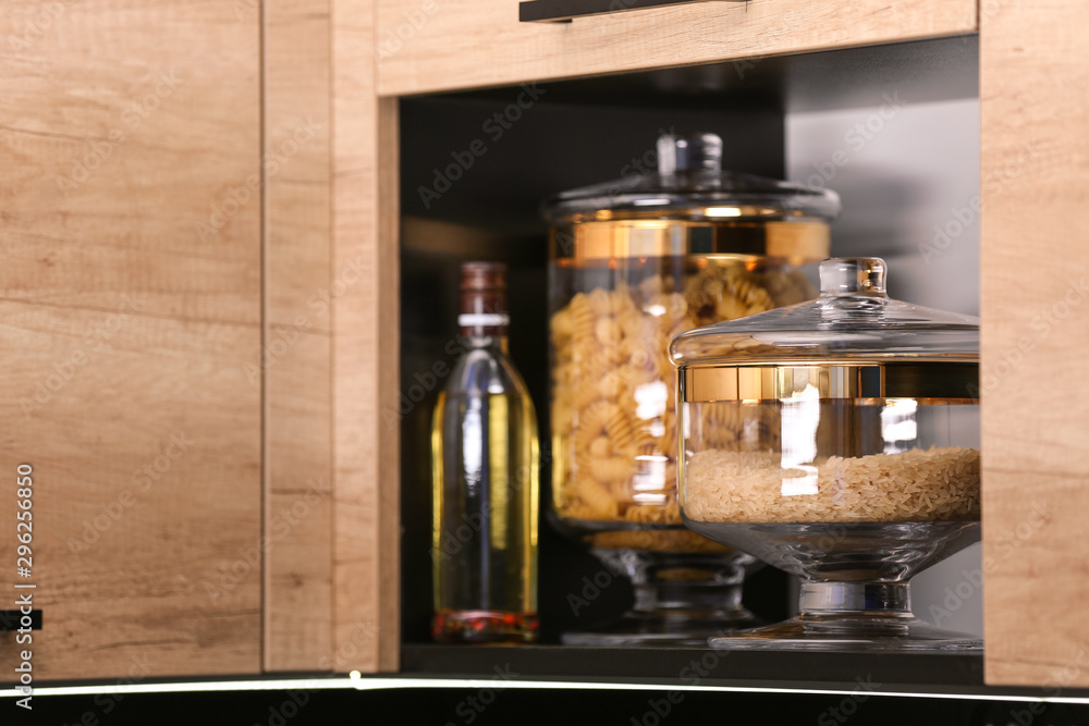 Shelf with raw cereals in modern kitchen