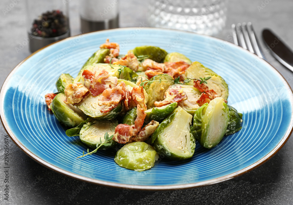 Delicious cooked Brussels sprouts with bacon served on grey table, closeup Delicious cooked Brussels sprouts with bacon served on grey table, closeup