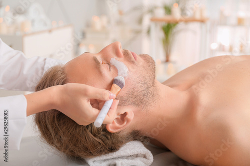 Cosmetologist applying mask onto man's face in spa salon © Pixel-Shot