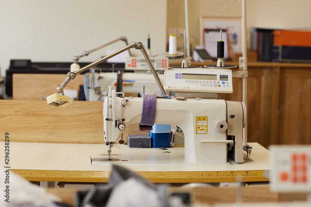 Image of sewing workshop with sewing machines on the tables ready for work