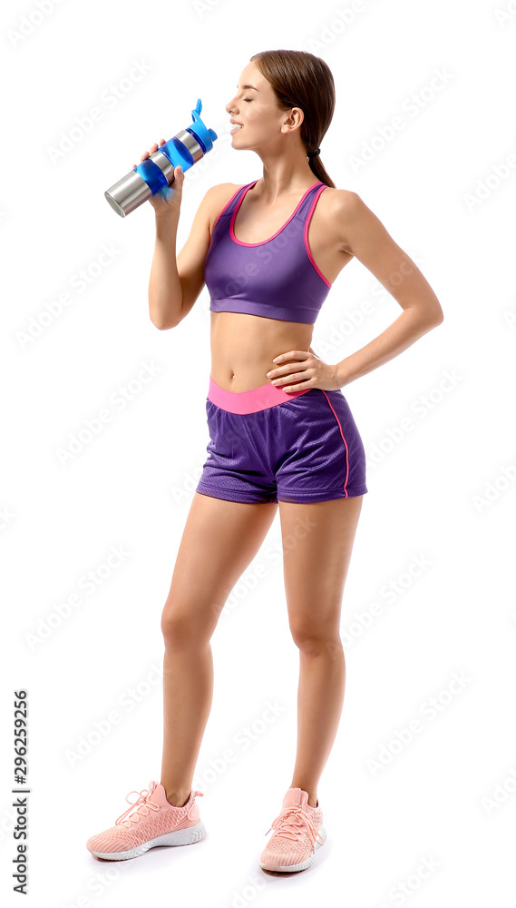 Sporty young woman drinking water against white background Sporty young woman drinking water against white background