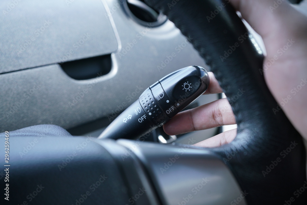Man hand use the signal switch. Car interior detail with dashboard and steering