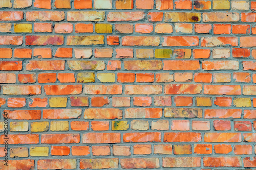 Bricks surface of urban wall painted in bright orange and yellow colors