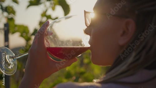 At sunset young woman stand the vineyards tasting the red wine glass sun grape sunset organic connecting with nature agriculture sunny travel countryside field green rural slow motion