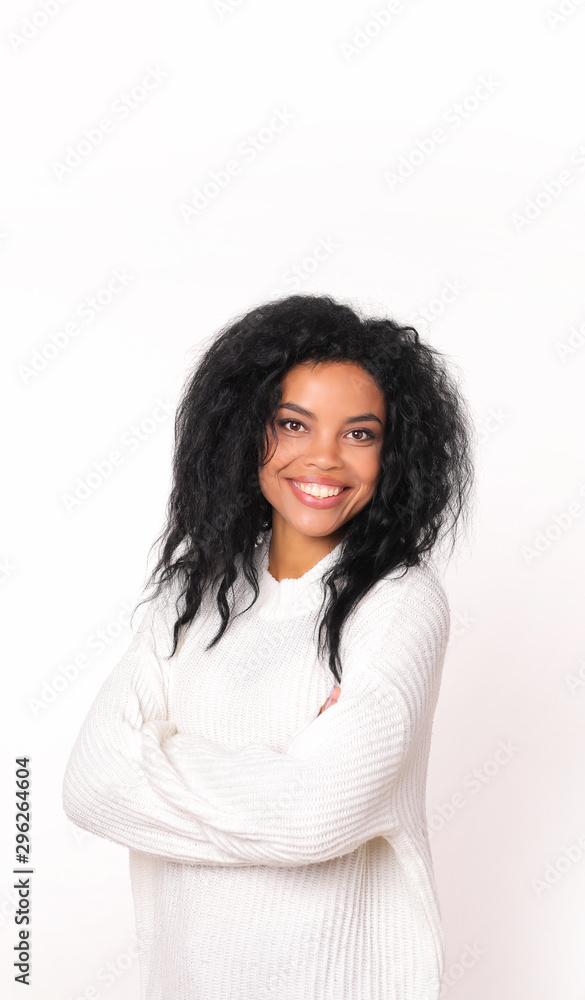 As right as rain. Lovely African American woman in snow-white knitted sweatshirt is posing with her arms folded, smiling and looking right at the camera. As right as rain. Lovely African American woman in snow-white knitted sweatshirt is posing with her arms folded, smiling and looking right at the camera.