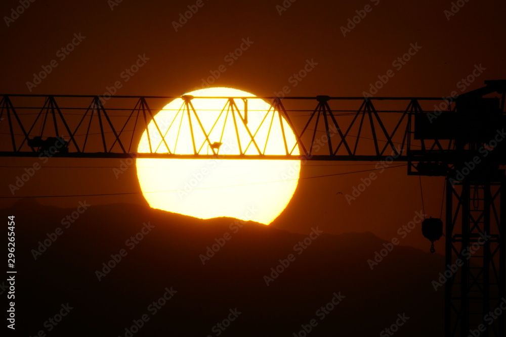 crane solar disk sunset disco solar al atardecer con grua de la construccion de edificios