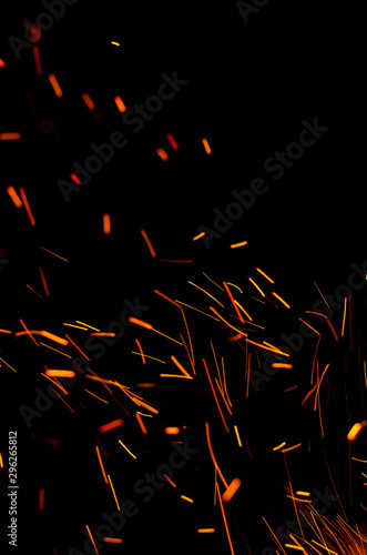 Obraz na płótnie Flying burning red sparks on a black background. Fiery orange glowing particles flying away in night sky. Abstract background. Copy space w salonie