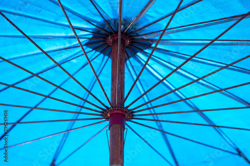 Close up view of the inside of an open, blue umbrella.