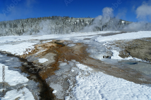 Snow melted by hot mineral water streams during winter in Yellostone National Park photo