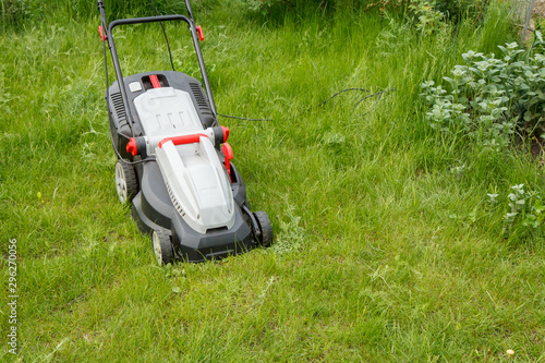 Lawn mower on green grass in the garden