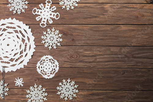 Different paper snowflakes on wooden board