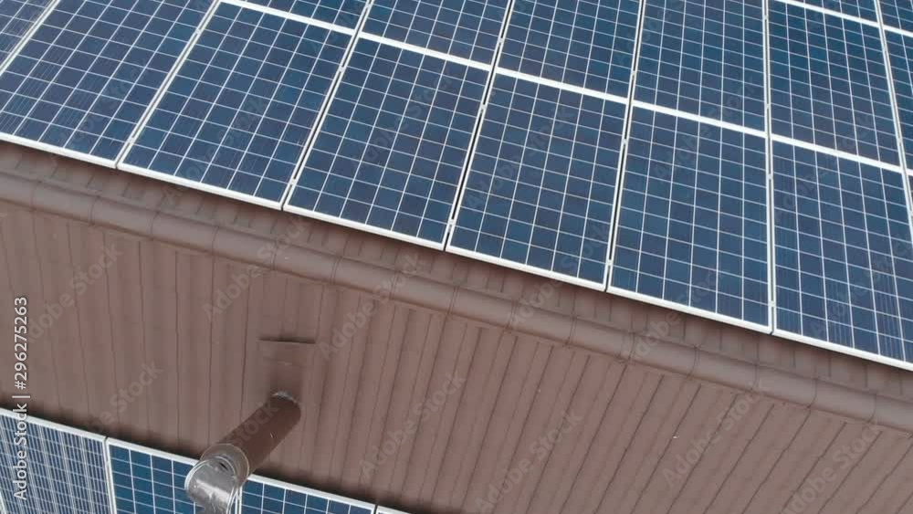 Rotating zoom drone shot of the panels of small solar power plant mounted on the roof top of house. Alternative energy sources. Ecological production of electricity without environment pollution Rotating zoom drone shot of the panels of small solar power plant mounted on the roof top of house. Alternative energy sources. Ecological production of electricity without environment pollution