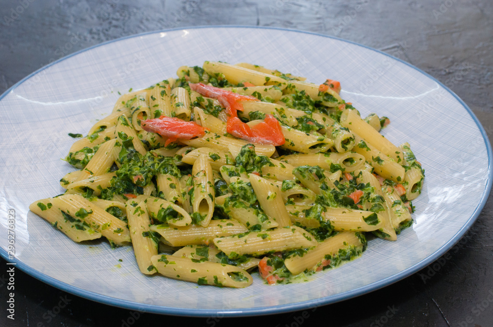 Delicious traditional Italian dish pasta with salmon, spinach and cheese.